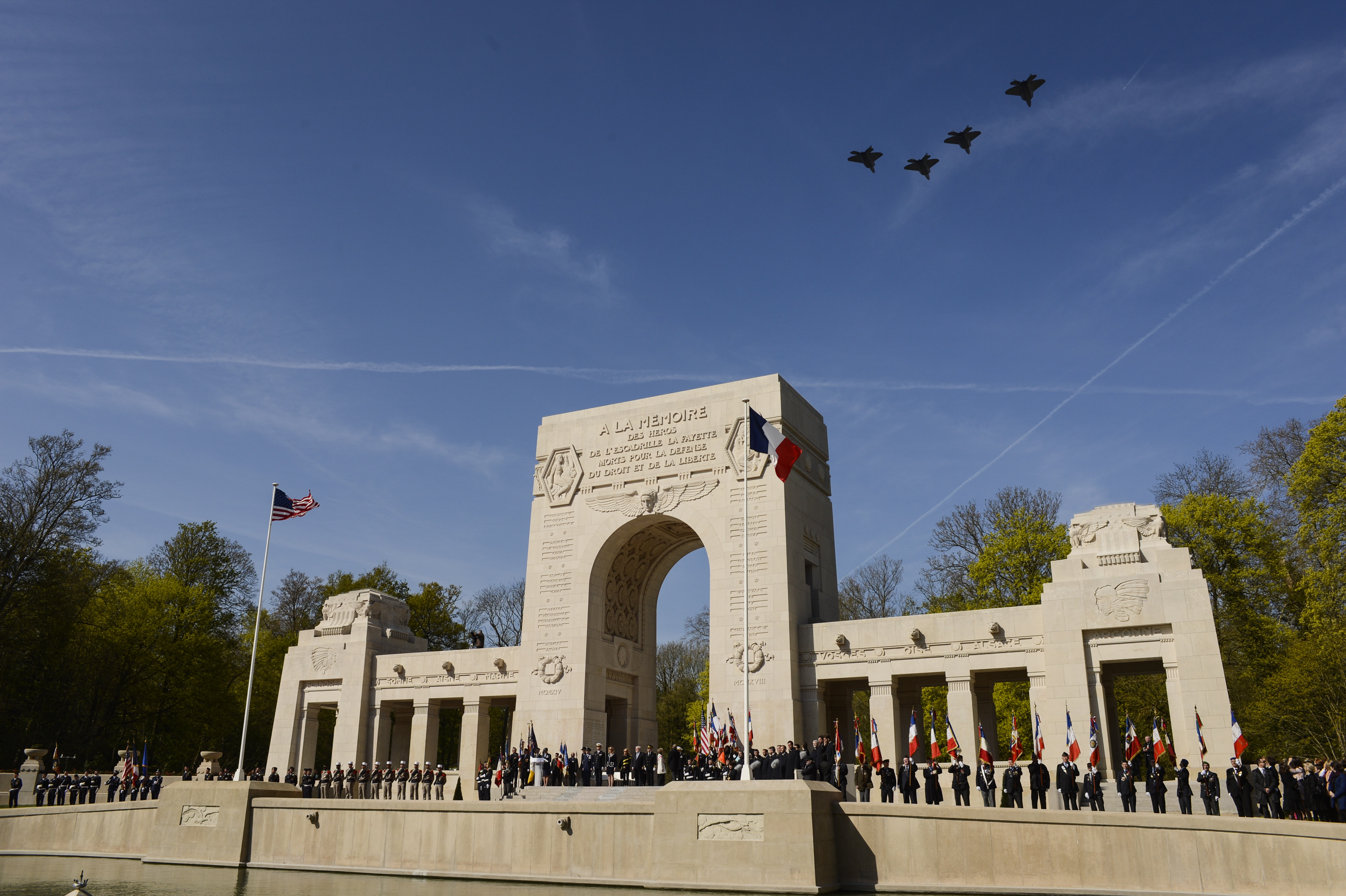Four U.S. Air Force F-22 Raptor fifth generation fighters fly over the Lafayette Escadrille Memorial in Marnes-la-Coquette, France, April 20, 2016, during a ceremony honoring the 268 Americans who joined the French Air Force before the U.S. officially engaged in World War I. In addition to the F-22s, a USAF B-52 Stratofortress bomber, three FAF Mirage 2000Ns, one FAF Rafale and a World War I-era Stearman PT-17 biplane performed flyovers during the ceremony commemorating the 100th anniversary of the Layfette Escadrille’s formation. Men of the Lafayette Escadrille and Lafayette Flying Crops were critical to the formation of the U.S. Air Force. (U.S. Air Force Photo by Tech. Sgt. Joshua DeMotts/Released)
