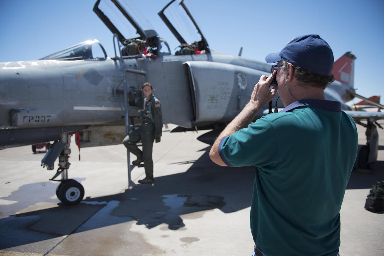 Retired Col. David takes a photo of his daughter, Cadet 2nd Class Kaitlyn, standing next to an F-4 Phantom on July 12, 2016 at Holloman Air Force Base, N.M. David came to surprise his daughter, a junior at the Air Force Academy, after her first flight in a fighter jet with the 82nd Aerial Target Squadron. (Last names are being withheld due to operational requirements.