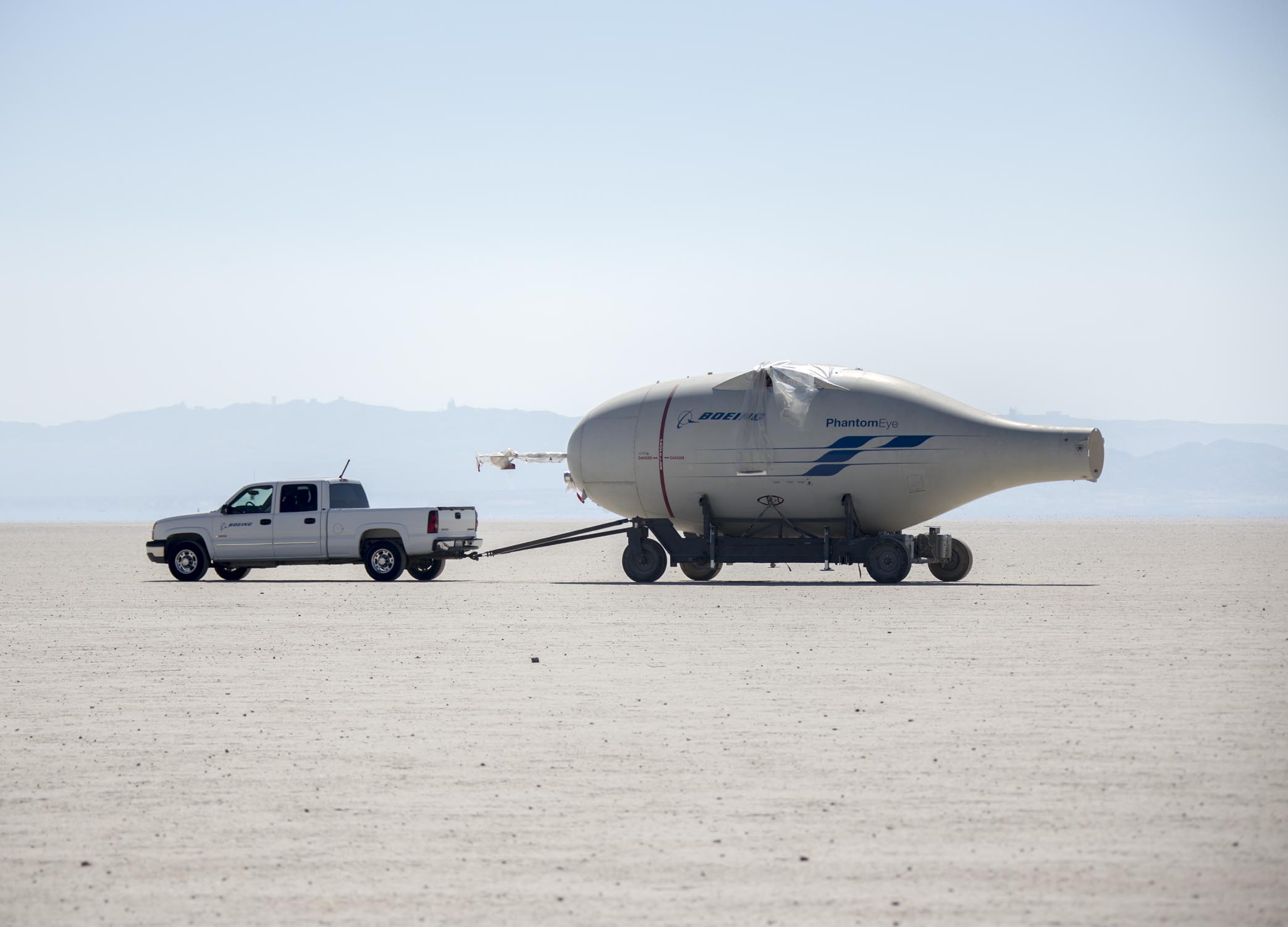 EDWARDS AIR FORCE BASE, Calif. (Aug. 17, 2016) Photos of NASA employees moving the disassembled Phantom Eye, a Boeing-developed, liquid hydrogen-powered demonstrator aircraft, during a transfer from the NASA Armstrong Flight Research Center across Rogers Dry Lake to the red-topped Hanger 4305 on North Base, where the aircraft will await reassembly and refurbishment for eventual display as part of the Air Force Flight Test Museum. Phantom Eye was designed to fly long endurance missions at high altitudes as a potential surrogate for military intelligence and communications satellites. Smoke from the Blue Cut Fire can be seen in the background of some images. (U.S. Air Force photo by Christopher Okula)