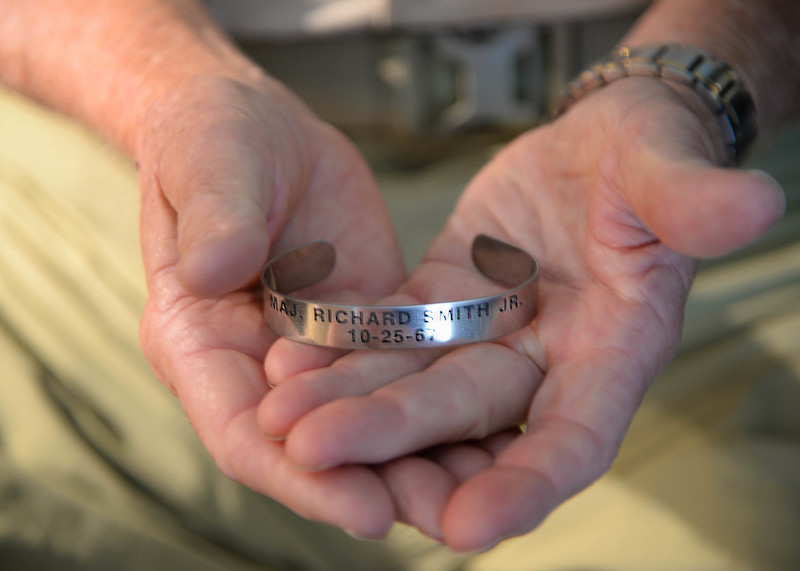Retired Lt. Col. Richard “Gene” Smith, former 50th Flying Training Squadron Commander, holds a prisoner of war bracelet Oct. 17, 2017, in his home in West Point, Mississippi. The bracelet was one of hundreds he had returned to him after he was repatriated. The date Smith was shot down, Oct. 25, 1967, is inscribed on the bracelet, along with his rank and name. The bracelets help keep the memory of POWs and those missing in action. (U.S Air Force photo by Airman 1st Class Beaux Hebert)