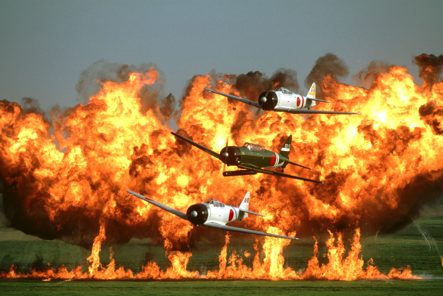 Aircraft from the CAF's famous Tora! Tora! Tora! display routine fly past the crowd as pyrotechnics fill the air to their rear! (photo CAF Tora! Tora! Tora! team)