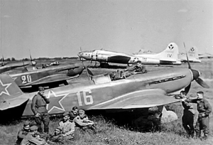 USAAF B-17 Flying Fortresses and Soviet Air Force Yakovlev Yak-9 fighters share an airfield as aircrews swap stories in 1944.