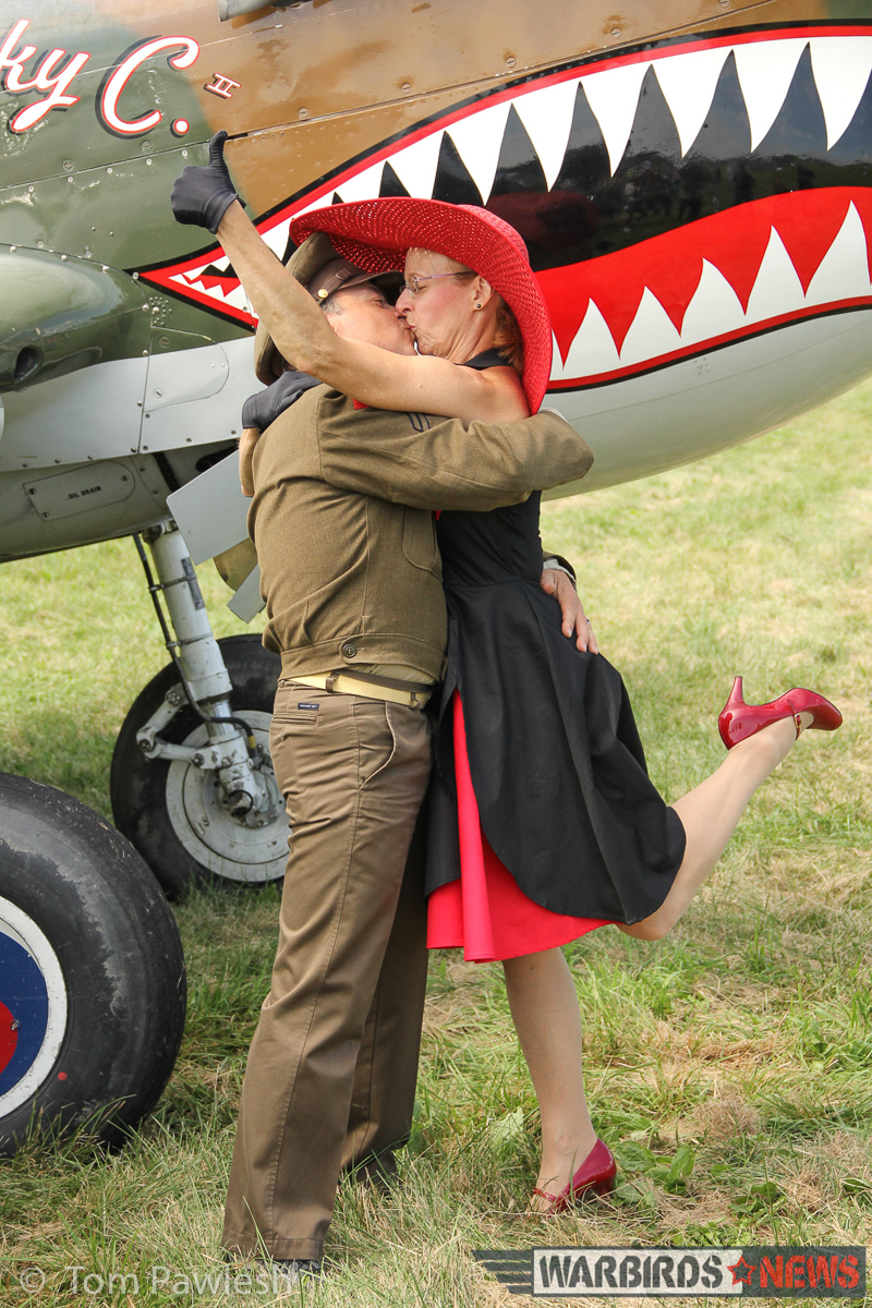 A pair of WWII re-enactors share a bit of romance in front of the Warhawk... and why not indeed? (Photo by Tom Pawlesh)