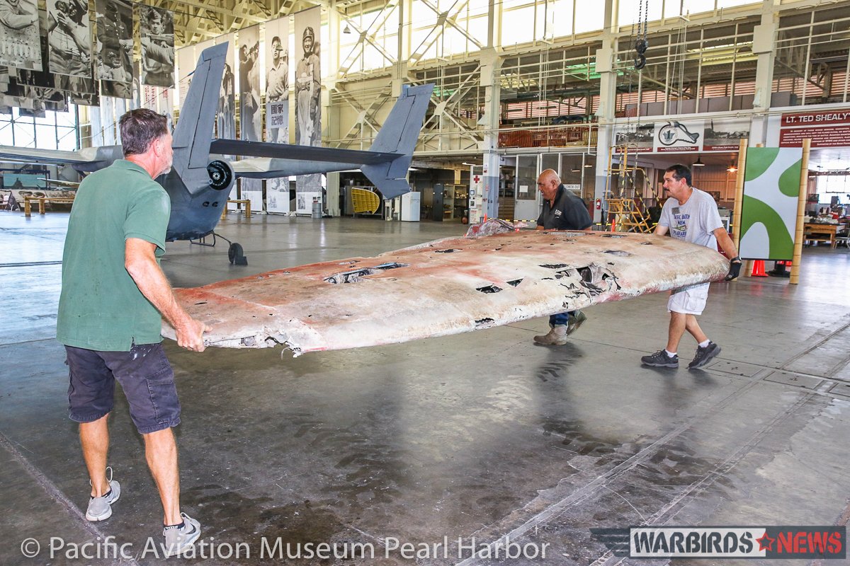 Lifting the starboard outer wing panel. (photo via Pacific Aviation Museum Pearl Harbor) 