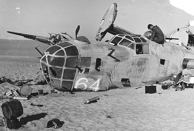 A man investigates the remains of Lady Be Good in the Libyan desert during a recovery operation in 1960. (USAF photo via Wikipedia)