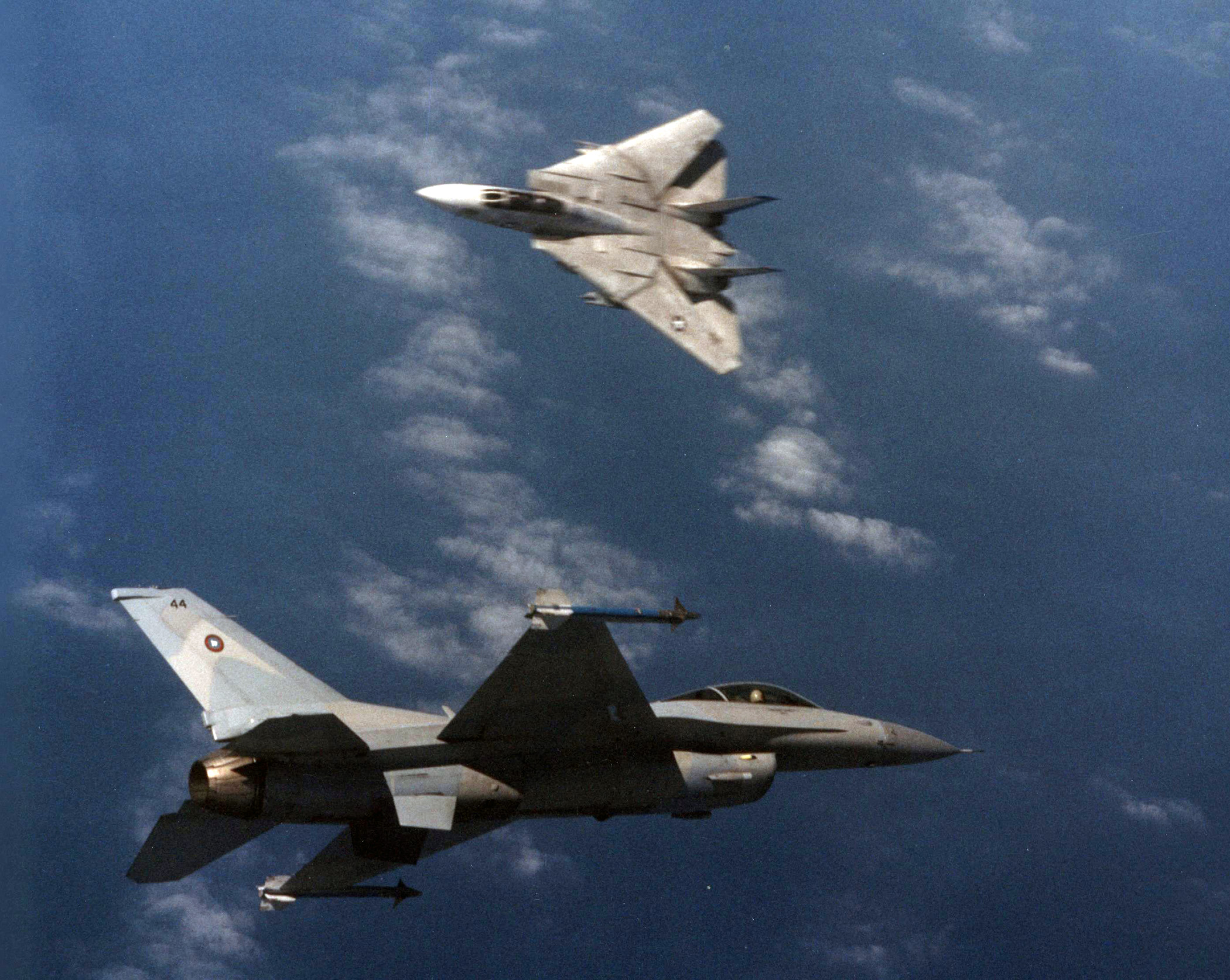 An F-14A Tomcat of Fighter Squadron (VF) 213 flown by CDR Greg "Mullet" Gerard and LTJG Don "Coach" Husten engages and F-16N Viper aggressor aircraft flown by Lieutenant Commander George "Elwood" Dom during training at the Navy Fighter Weapons School (TOPGUN) at Naval Air Station (NAS) Miramar, California, in March 1989. Later in his career, Dom served as flight leader of the Blue Angels. (Robert L. Lawson Photograph Collection, National Naval Aviation Museum)