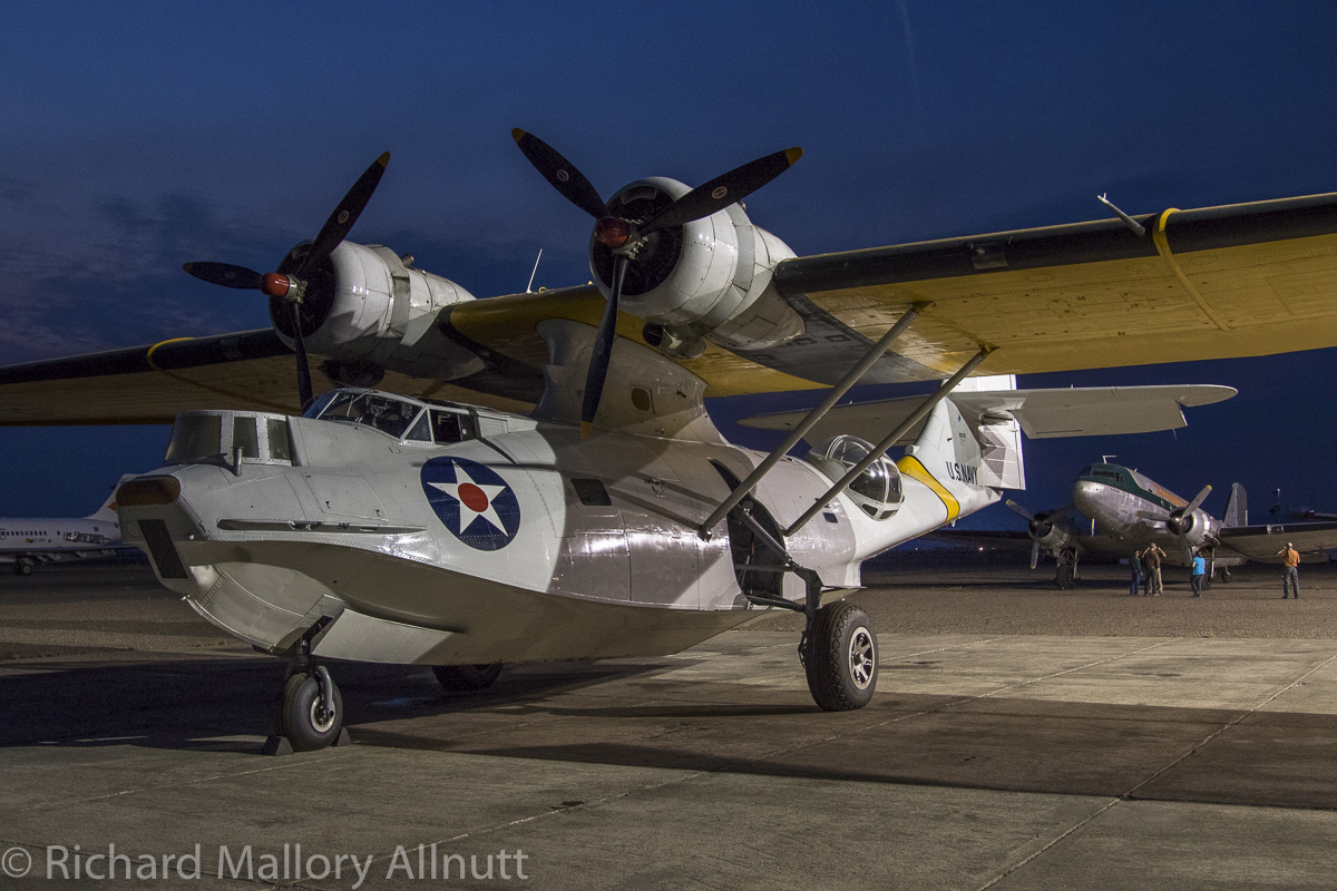 The Erickson Aircraft Collection's PBY and DC-3 lit up with the light from tonight's  hangar party. (photo by Richard Mallory Allnutt)