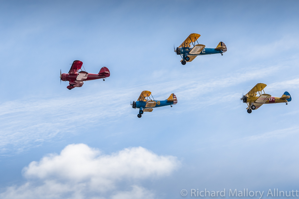 Two WACOs and two Stearman biplanes from the Bealeton Flying Circus fly by in formation. Based nearby in Bealeton, the Flying Circus thrills the crowds every Sunday from May to the end of October each year since the early 1970s. (photo by Richard Mallory Allnutt)
