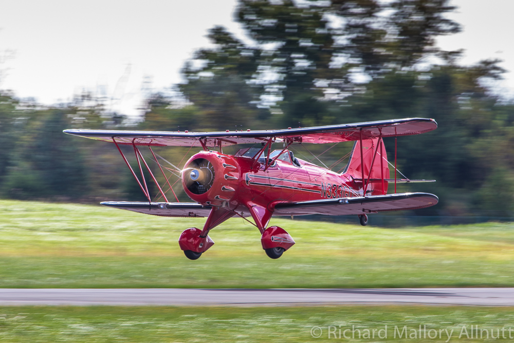 John Corradi lands his magnificent scarlet WACO YMF reproduction following his display routine. A Viet Nam veteran, Corradi is one of the stalwarts of the Bealeton Flying Circus, located just down the road from Culpeper in Bealeton, Virginia. (photo by Richard Mallory Allnutt)