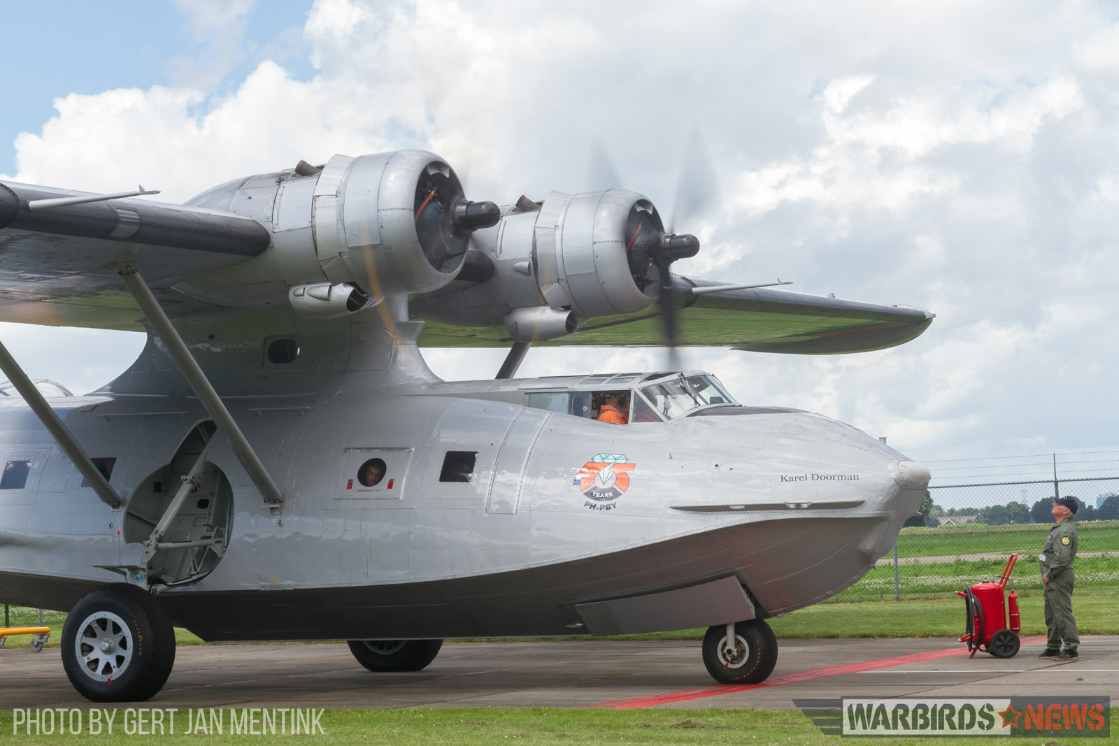 PH-PBY's Pratt & Whitney R-1830's have just been fired up and need some warming before take-off. One of the Catalina Association volunteer keeps an eye on their condition. The inevitable fire extinguisher within reach! (Gert Jan Mentink)