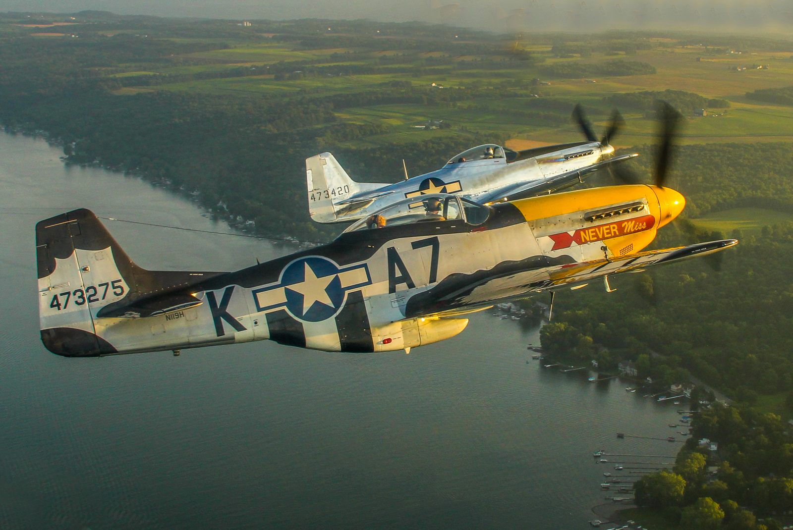 A stunning air-to-air of Mustangs over the Genesee Valley with Mark Murphy flying 'Never Miss' and Andrew McKenna in his factory-fresh P-51D. (photo by Tom Pawlesh)