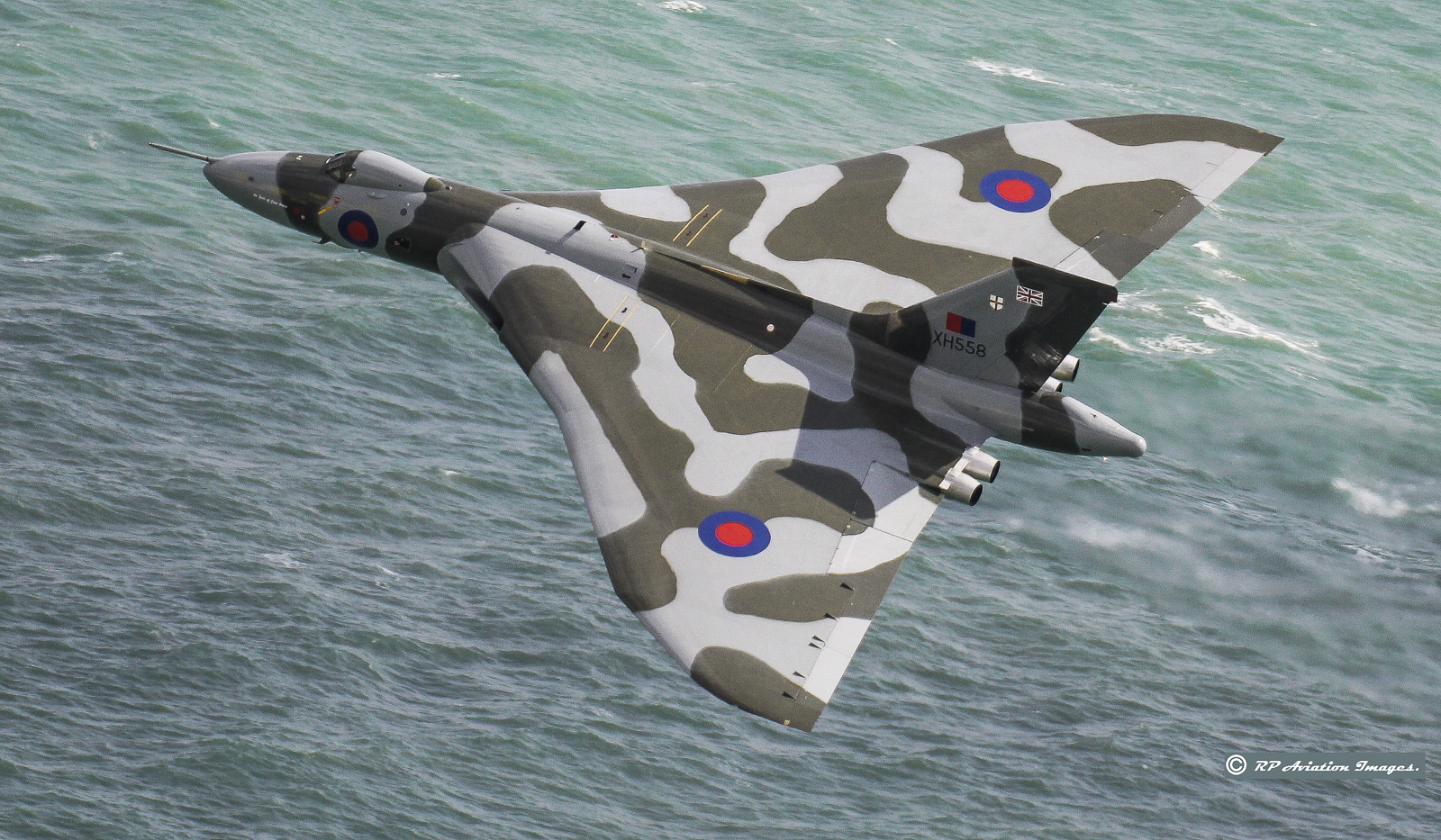 A fabulous view of XH558 as she roars over the water at Beachy Head in southern England. (photo by Robin Pettifer)