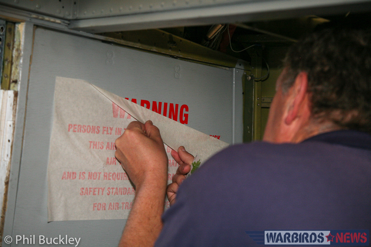 Richard Thompson applying the Warning decal inside the . (photo by Phil Buckley)