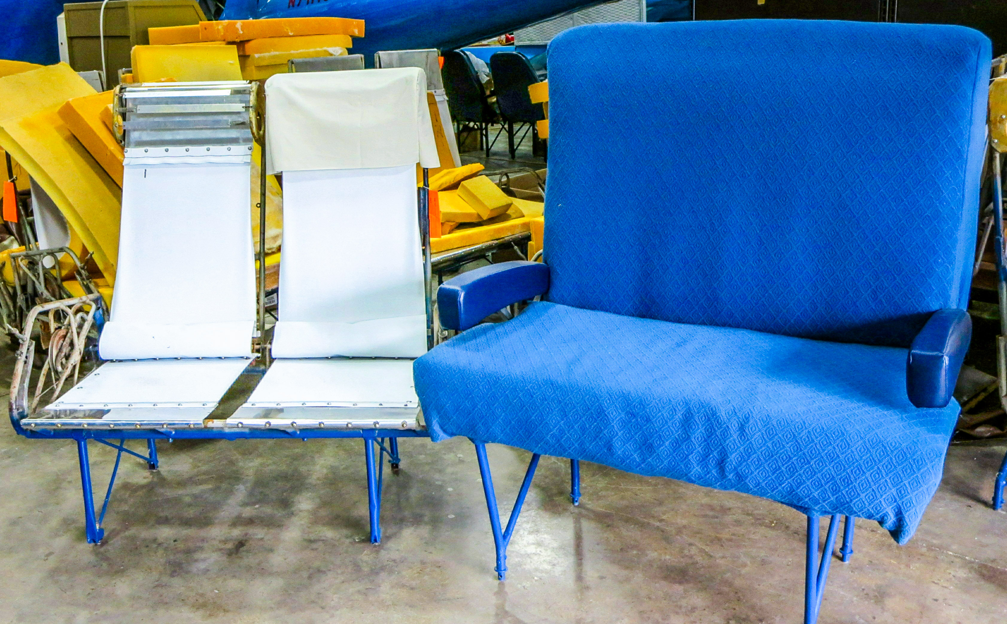 An example of the passenger seat support structure can be seen on the left, with the completed, re-upholstered Flight Attendant seat on the right. (photo via NEAM)