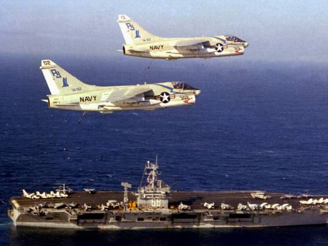 Two A7 Corsairs soar above the USS Nimitz in 1979. The top aircraft, plane 303, is on display at Edwardsville Township Community Park and will be restored with the help of the Flight Deck Veterans Group ( US NAVY Archives/A-7 Assn)