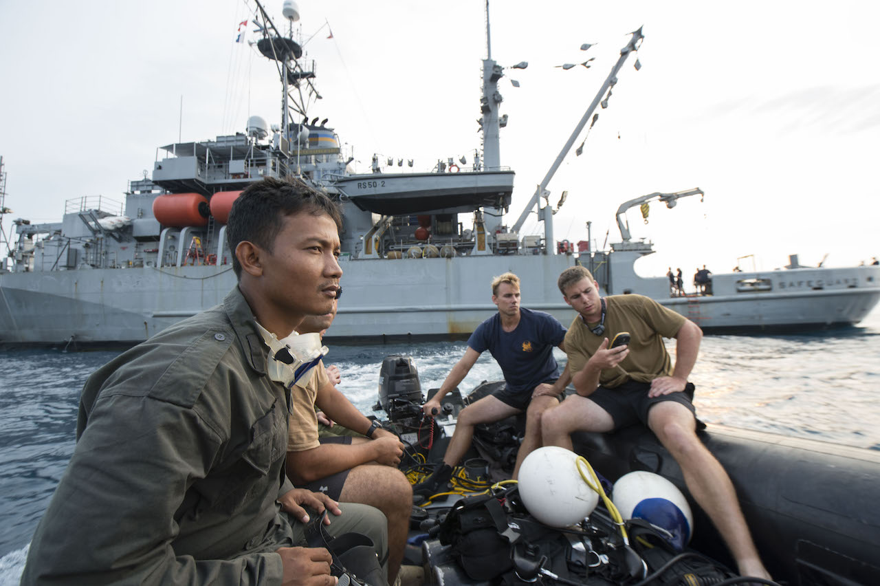  Navy Divers assigned to Explosive Ordnance Disposal Mobile Unit 11, Mobile Diving Salvage (MDS) 11-7, and an Indonesian Navy diver prepare for dive operations held in support of search and survey operations of the sunken World War II navy vessels USS Houston (CA 30) and HMAS Perth (D29). The data collected by the dive exercise will help the U.S. embassy in Indonesia and Naval Historical Heritage Command catalog the current state of the wrecks. (U.S. Navy photo by Mass Communication Specialist 2nd Class Arthurgwain L. Marquez/Released)