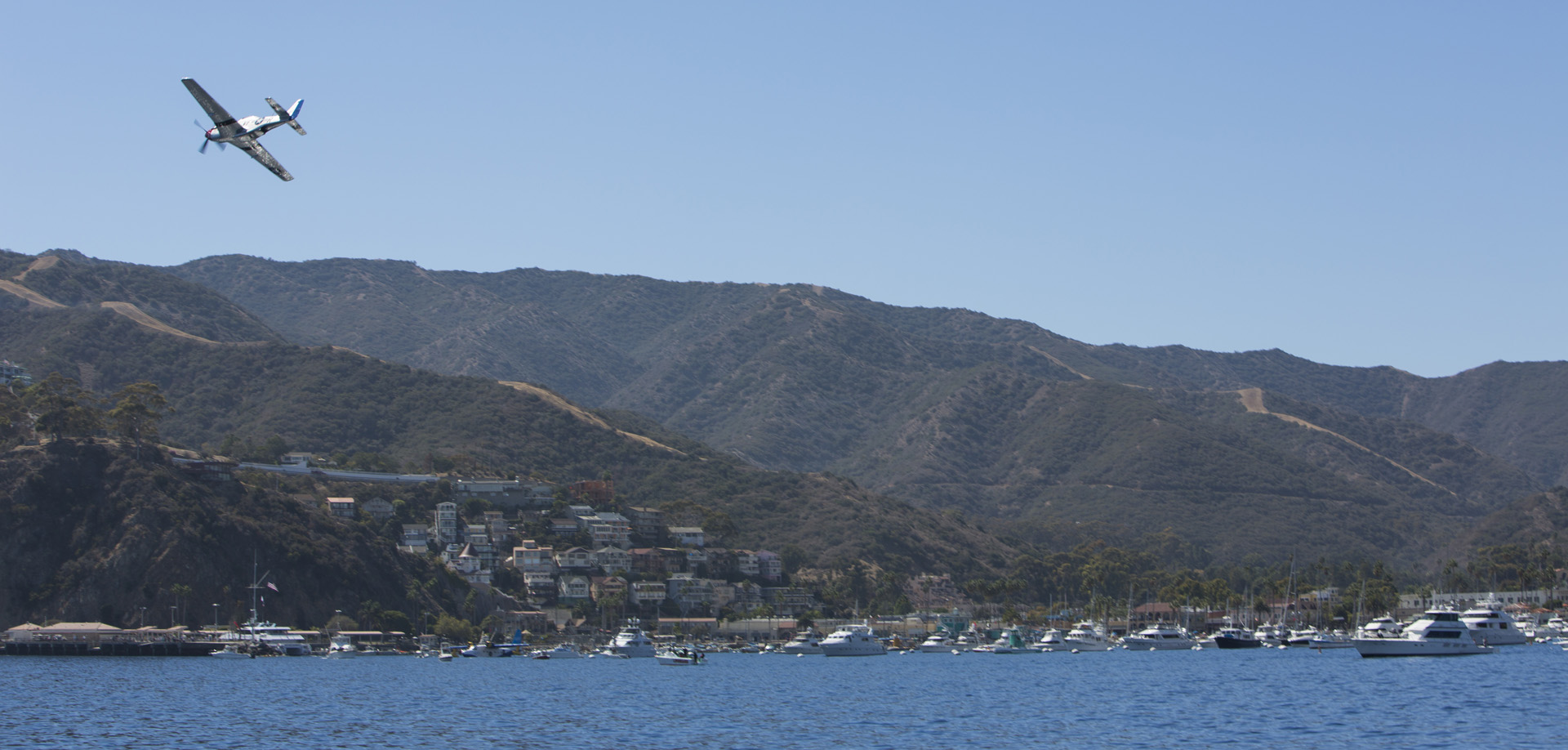 A P-51 Mustang flying over Avalon Harbor at the Catalina Air Show last year. (photo via Catalina Air Show)