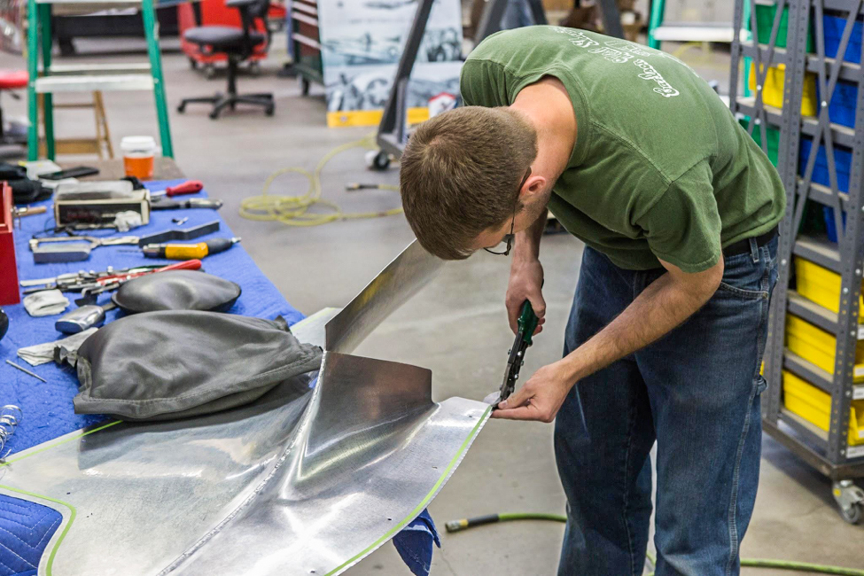 Randy carefully trims a fillet piece that smooths the wing trailing edge to fuselage juncture. (photo via AirCorps Aviation)