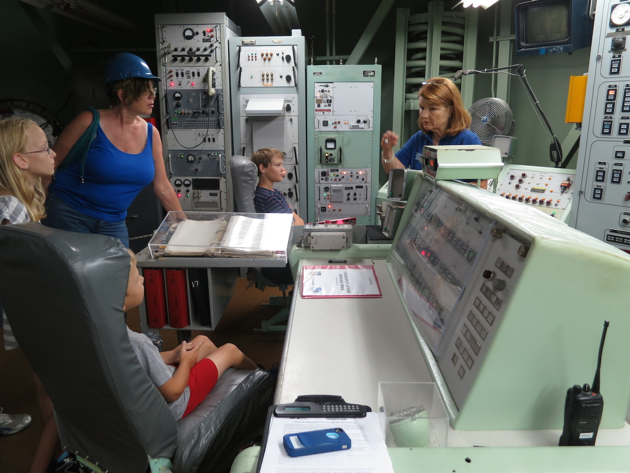 A family experiencing the Titan Launch Control Center tour with docent and past crew member Maggie.