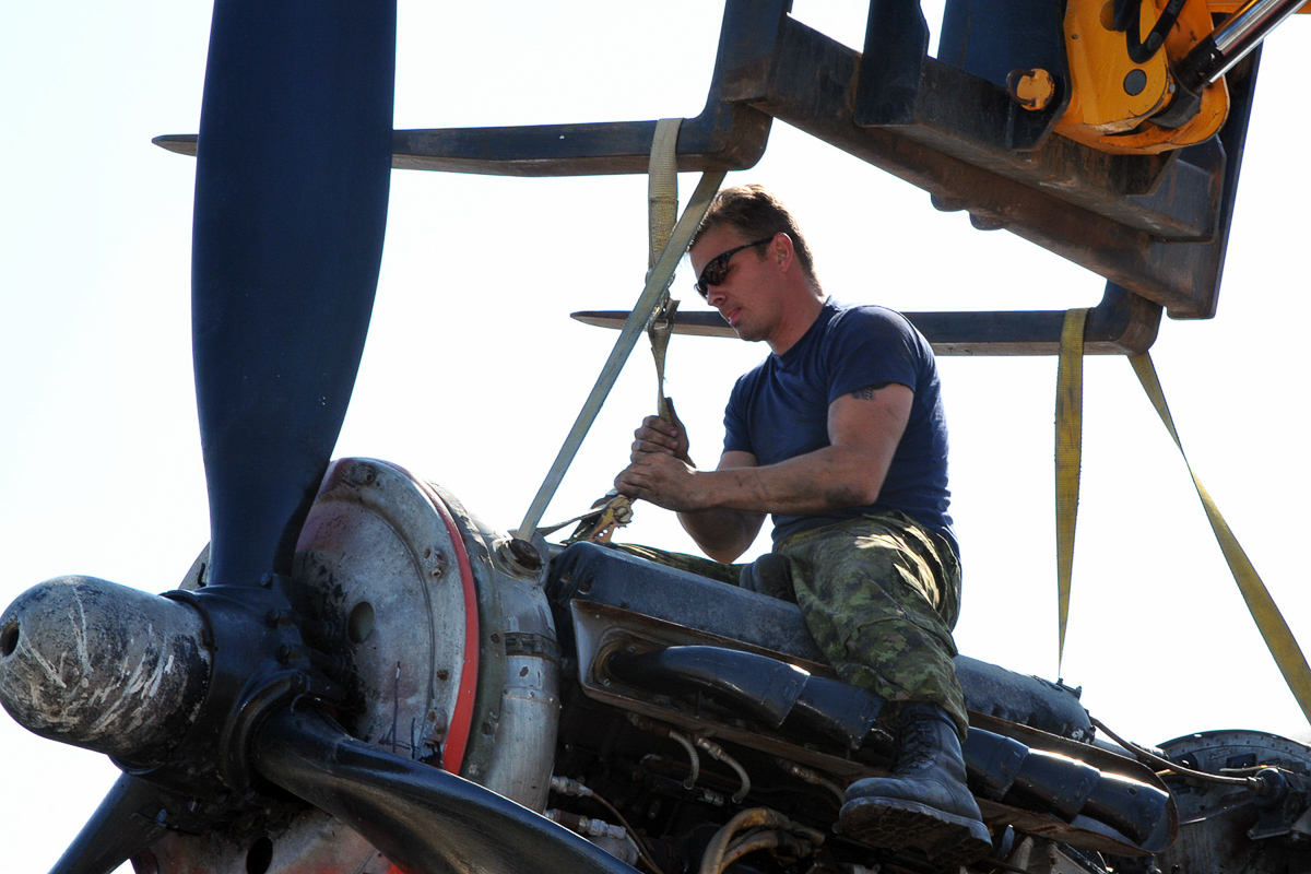 An RCAF technician from ATESS tightens straps on one of KB882’s engines in preparation for its removal. (Photo by Warrant Officer Fran Gaudet DND)
