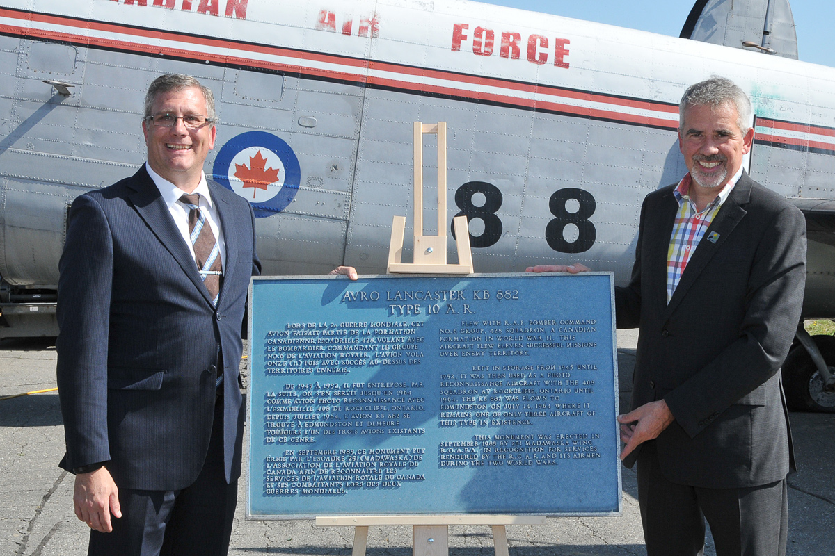 Mayor Cyrille Simard (right) presents Kevin Windsor, curator of the National Air Force Museum of Canada, with the historic plaque that was affixed to a plinth in front of KB882. (Photo by Warrant Officer Fran Gaudet DND)